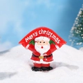 Miniature resin Santa Claus figurine holding a Merry Christmas banner on snow - Santa Claus with Banner