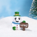 Miniatura de muñeco de nieve de resina con bufanda azul y cartel XMAS sobre nieve - No.2 (Sombrero Verde Bufanda Azul con Señal XMAS)
