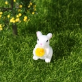 Miniature white bunny figurine holding a small yellow flower for garden landscape decor - Rabbit