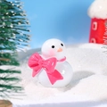 Miniature snowman figurine with pink bow tie standing in snowy winter micro landscape - Snowman with Pink Bow