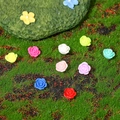 Ciondoli mini rosa in resina in colori assortiti su uno sfondo di muschio verde - Rosa Colorata