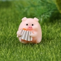 Cute pink resin pig figurine playing a white accordion on green grass garden decor - Accordion Pig