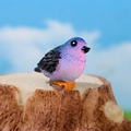 Miniature blue resin bird figurine with purple gradient on realistic tree stump - Bird / Blue