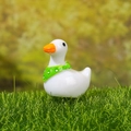 Miniature white duck resin figurine with green polka dot scarf on green moss grass - Duck with Green Scarf