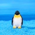 Miniature resin penguin figurine with yellow accents on blue decorative sand base - Standing Penguin (Style A)