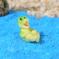 Miniatura di coccodrillo in resina verde disteso su sabbia decorativa blu per acquari - Stile C