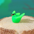 Miniature green resin hummingbird figurine with orange beak on a rustic wood base - Green