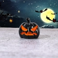 Glossy black Halloween pumpkin resin ornament with orange Jack-o'-lantern face - Dark Angry Pumpkin
