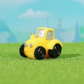 Miniature yellow resin farm tractor figurine on green grass lawn micro landscape - Yellow