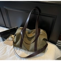 Nahaufnahme der olivgrünen Canvas-Tasche mit braunen Ledergriffen und Schultergurt - Grün