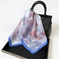 Seidig quadratisches Halstuch mit Blumenmuster in Blau und Rot auf Handtasche - Blau