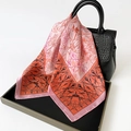Floral satin square silk scarf in pink and orange draped over a stylish black handbag - Pink