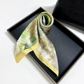 Floral print silk scarf with yellow borders displayed on a black elegant tray - Green