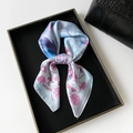 Light blue floral square silk scarf with pink rose print on a dark tray with a handbag - Square Style / Blue