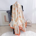 Détail d'un foulard en soie aux motifs floraux orange chaud et finitions d'ourlet orange - Orange
