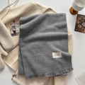 Solid grey tassel scarf with woven texture and premium brand label detail - Space Gray