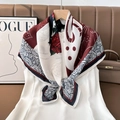 Detail of red floral silk scarf draped over white dress featuring paisley patterns - Color 19