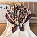 Detailed view of silk scarf with paisley patterns hanging on a wooden hanger - Color 16