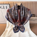 Detailed view of luxury silk scarf with paisley patterns hanging on wooden hanger - Color 18