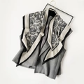 Nahaufnahme eines beigen Seidenschals mit Paisley-Muster über einer grauen Weste - Damast Floral (SJJ058-Schwarz)