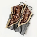 Close-up of vintage paisley pattern silk scarf draped over a grey business suit - Orange