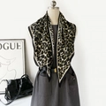 Chic leopard print oversized shawl in olive green and beige on a stylish mannequin - Green