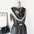 Detail of paisley floral silk scarf styled with a dark dress and a metallic belt buckle - Black