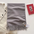 Sciarpa grigia effetto cashmere con frange e etichetta su un cappotto bianco - Grigio Argento
