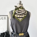 Detail showing high-quality silk scarf with classic horse prints on a mannequin - Green