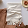 Écharpe unie beige crème avec franges sur un manteau en laine marron chaud - Blanc