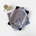 Detailaufnahme von blauem Paisley-Seidentuch mit Satin-Finish auf schwarzem Tablett - Hellblauer Zirkon
