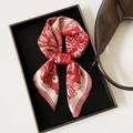 Detalle de pañuelo de seda rojo y blanco con estampado floral y bolso de cuero - Rojo