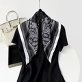 Dettaglio di un foulard in seta con stampa paisley bianca classica su fondo nero - Sfondo Nero Stile Floreale Bianco / Nero