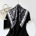 Dettaglio di un elegante foulard in seta con stampe floreali bianche e bordi a righe - Nero