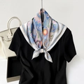 Detailed view of floral print satin scarf styled on a black top with vivid citrus patterns - 70x70cm / Pomegranate Blue