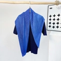 Detail of bright blue pleated silk scarf texture draped over navy ribbed knitwear - Pleating / Royal Blue