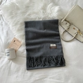 Detail view of dark grey scarf with long tassels and premium woven texture labels - Heather Grey