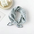 Detailed view of light blue floral cotton scarf featuring a delicate hand-tied knot - Blue With Camellia