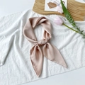 Detail of elegant champagne pink satin scarf with a smooth finish and decorative knot - Champagne