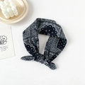 Detail of a black paisley cotton headscarf tied in a stylish knot on a white surface - Paisley Plaid Black