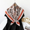 Close-up of retro paisley silk scarf with orange borders on a wooden hanger with props - Orange Red / 90cmx90cm