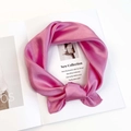 Close-up of bright magenta satin square scarf draped elegantly on a white magazine background - Sakura Pink