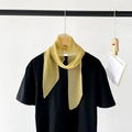 Elegante sciarpa plissettata giallo senape indossata come accessorio su un top nero - Giallo