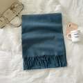 Deep blue-grey faux cashmere scarf with tassels, neatly folded on a bed in a lifestyle scene - Dusty Blue