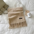 Beige cashmere blend shawl with fringe details and logo labels on textured surface - Beige