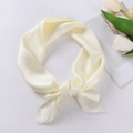 Eleganter cremefarbener Satin-Schal stilvoll geknotet vor weißen Tulpen-Blumen - 70x70cm / Beige