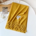 Close-up of mustard yellow fringe scarf showing dense twill texture and brand tag - Yellow
