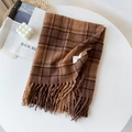 Détail de la texture d'écharpe à carreaux doux avec franges dans un décor d'hiver - Marron