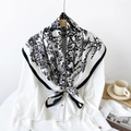 Elegant black and white floral twill silk scarf tied on white shirt over wooden hanger - White Flower Bird
