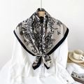 Elegant beige silk scarf with black floral and bird print draped on a hanger - Khaki Bird